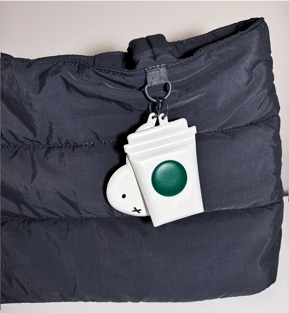 Close up image of the starbucks keychain on the bag.