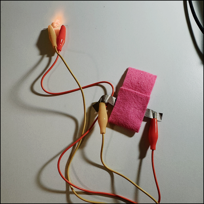 Constructed another neater battery holder by connecting the ends with fabric glue, tested by creating a simple circuit with alligator clips an light bulb