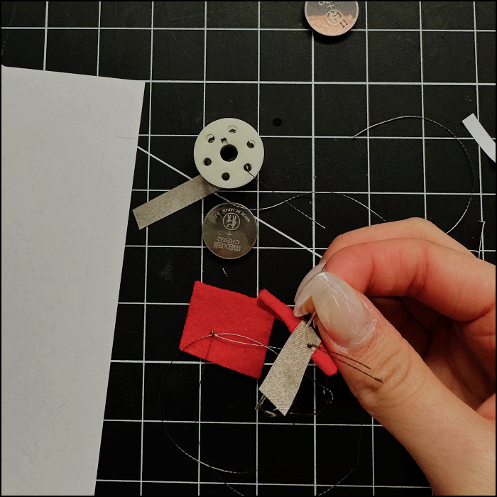 Image shows attempt to create the battery holder with felt and sewing with the conductive thread, through this experimentation it was discovered that the thread was less maleable than natural fibre thread and more difficult to work with.