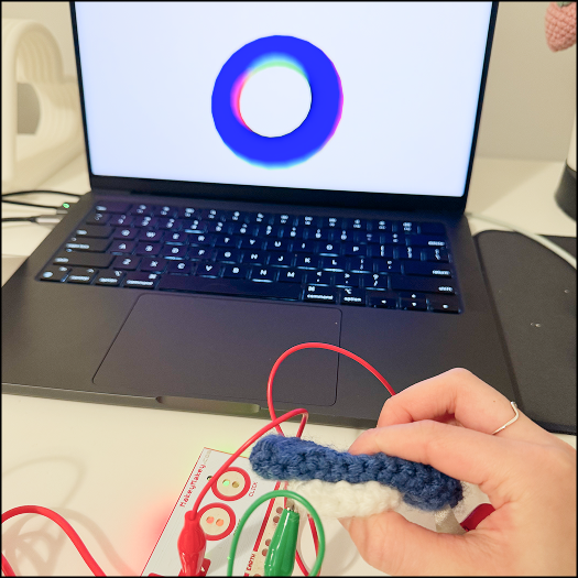 Testing if interaction could be triggered by pressing the conductive parts of the flower petal and circle together, while this succeeded it required a specific angle and pressing down with some force as the layer keeping the fabric in prevents them from touching easily.